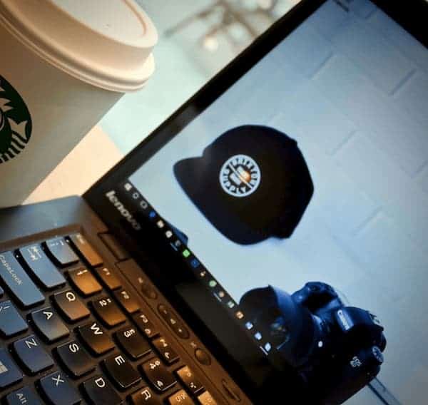 Un notebook Lenovo, con la pantalla encendida, mostrando una imagen de un sombrero sport y una cámara fotográfica. ¿Cómo escoger Internet inalámbrico para empresa?.